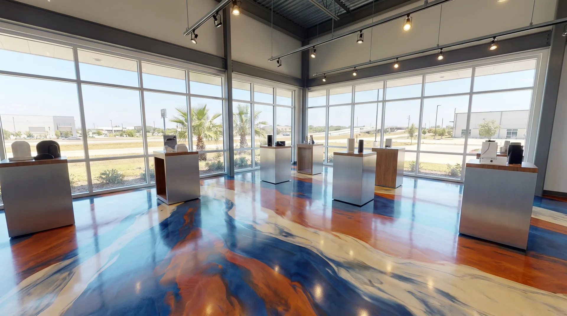 Custom colored epoxy floor coating matching brand colors in a San Antonio commercial showroom